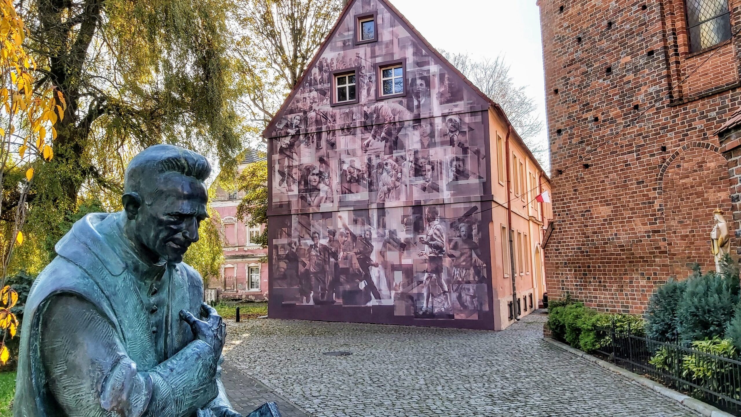 Fot. Tomasz Czyżniewski Postać ks. Kazimierza Michalskiego przypomina pomnik ustawiony nieopodal konkatedry pw. św. Jadwigi. Na ścianie budynku w głębi mural przestawiający sceny z Wydarzeń Zielonogórskich.