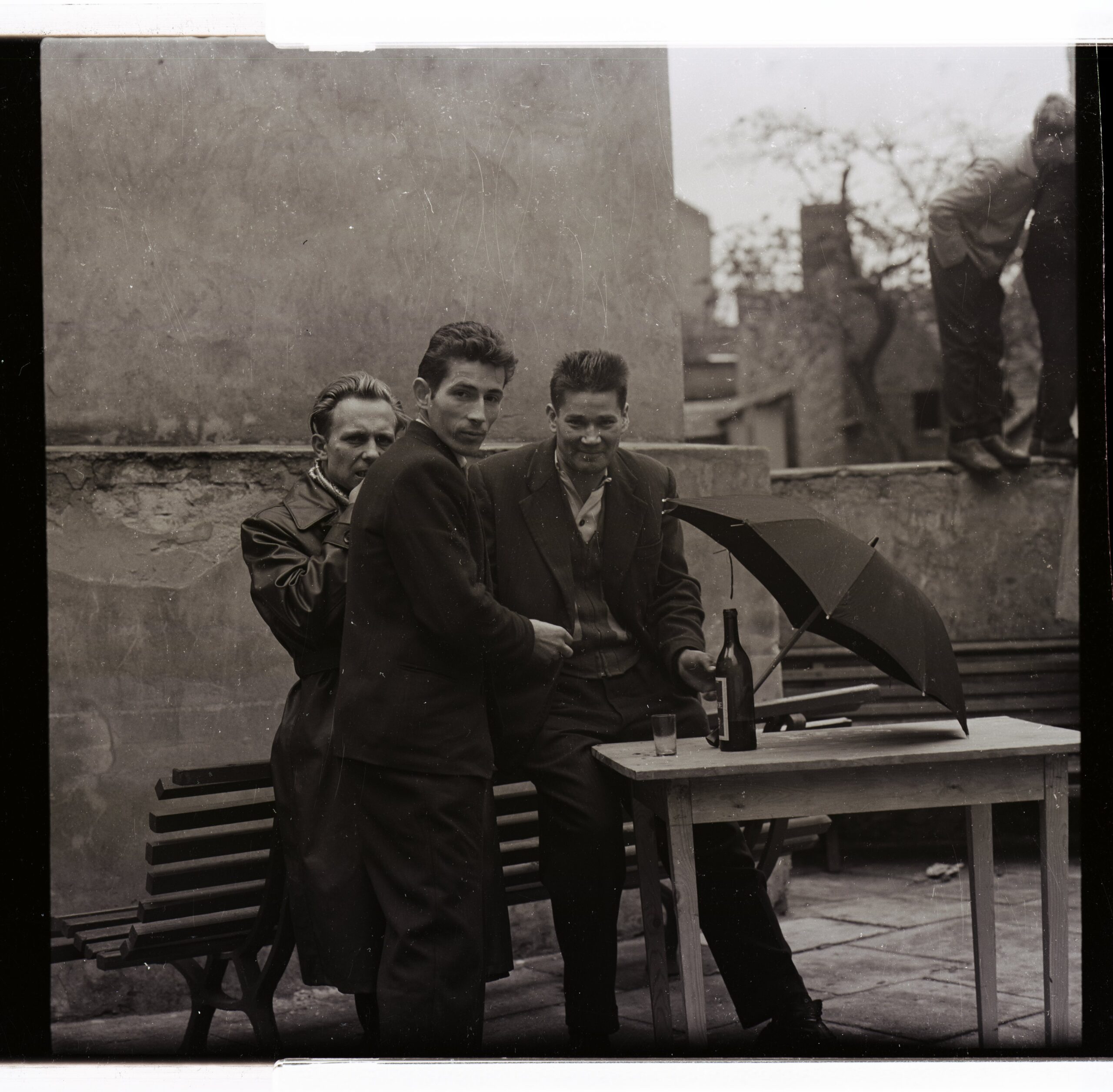 09-WIN panowie Winobranie w latach 60. XX w. Gdy zabawa trwa w najlepsze, deszcz nikomu nie przeszkadza. Grunt to chronić cenny trunek.